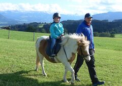 Kinder beim Ponyreiten auf dem Bauernhof im Allgäu