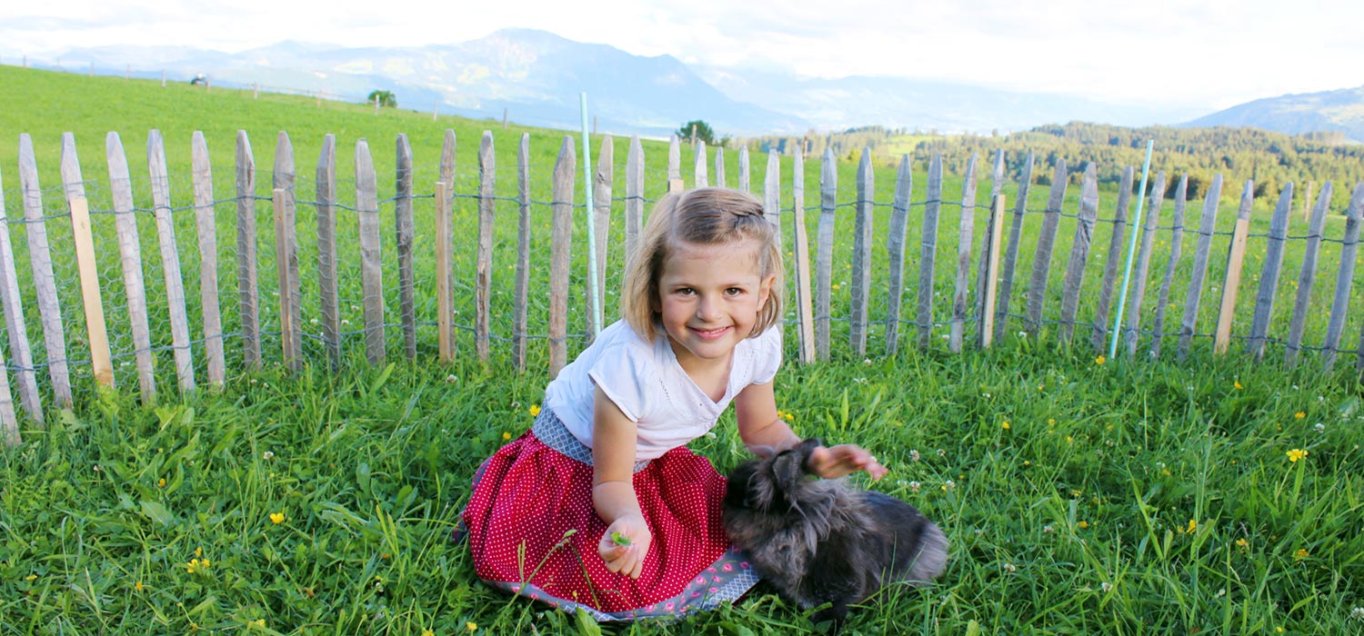 Mädchen mit Kaninchen beim Bauernhofurlaub im Oberallgäu